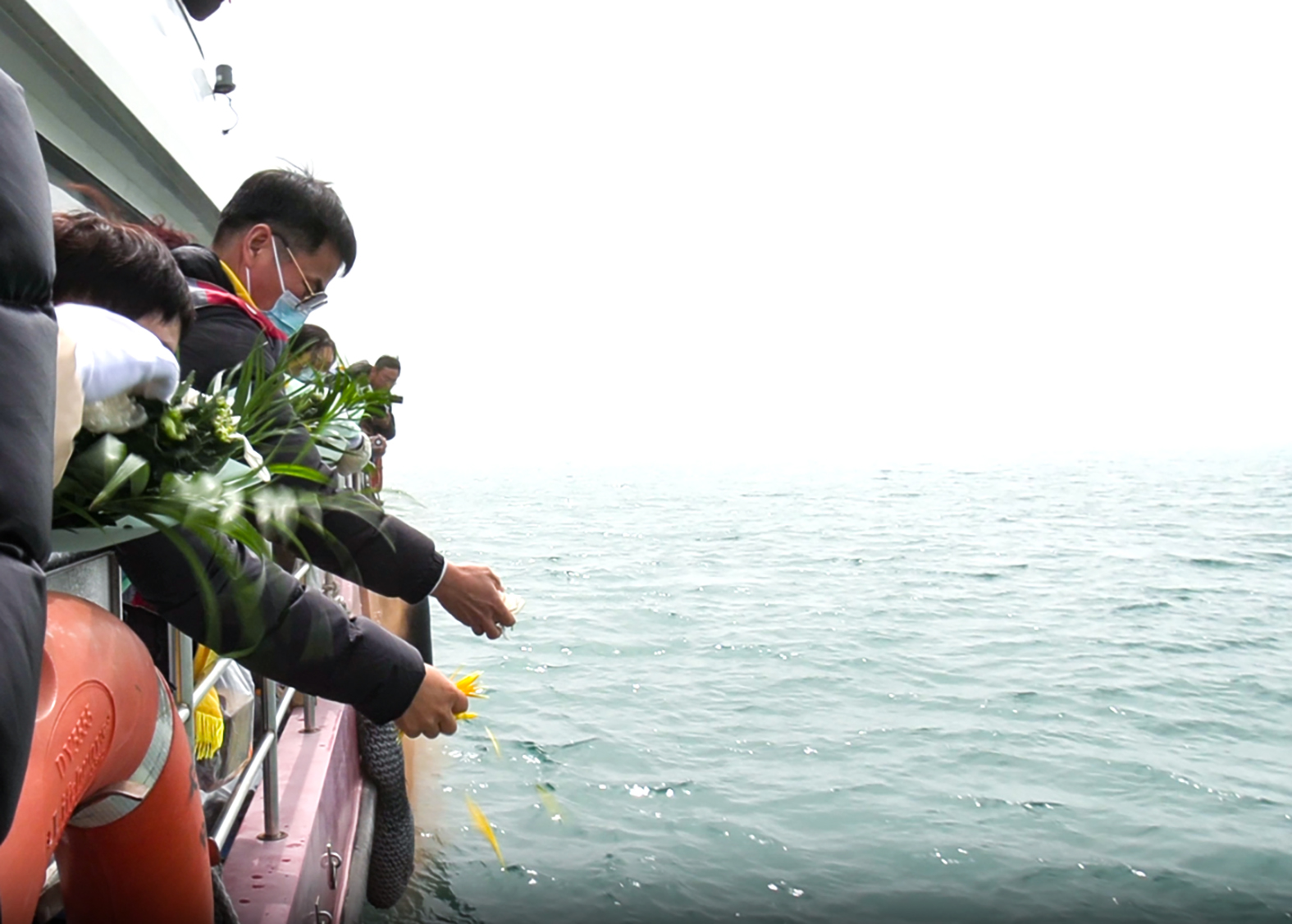 5 逝者家属在海上追思照片3——撒花瓣、水溶纸信封寄托哀思.jpg